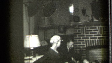 1939: men and women watching a baby play in front of a hearth DANIELSON