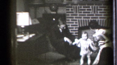 1939: a man and lady dress up his her child with full of love and enjoyment