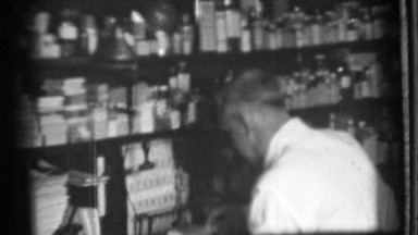 1939: store clerk works with the products of the store from shelf DANIELSON