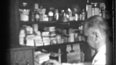 1939: older person appears to be selecting and arranging things in front