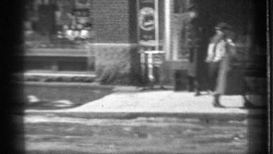 1939: people are walking on the wet sidewalk on a bright winter's day DANIELSON