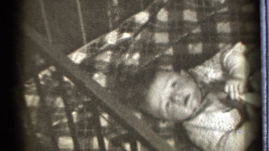 1939: a baby at the cradle and opening her eyes doing the movements of her legs