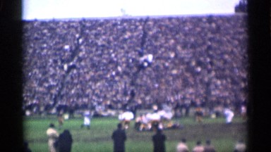 1944: big ground football match player follow the ball watch the people