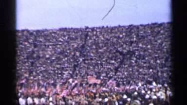1944: group of people carrying national flag parading among crowd