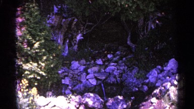 1960: exterior, showing enclosed, natural rock formation, with running water.