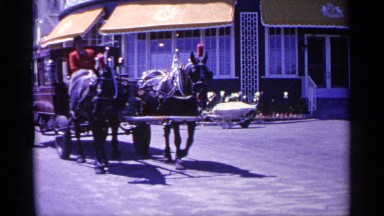 1960: transportation riding through a semi-busy street in a foreign country.