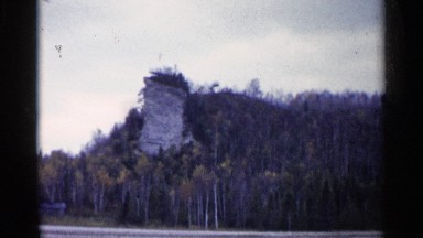 1960: tall cylindrical structure extends in front of round mountain MICHIGAN