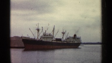 1960: a ship located alone at the water that looks like a river and some rocks