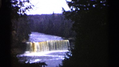 1960: a water falls flooding on the river and not stable some trees and plants