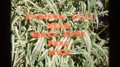 1960: a sign in the trees reading "rainbow falls near black river park