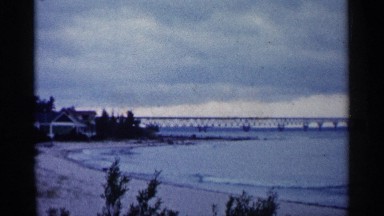 1960: a long bridge runs over the sea touching the beach with its waves MICHIGAN