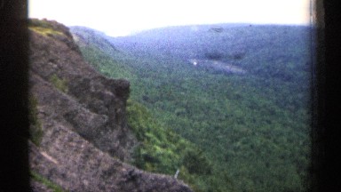 1960: a stream runs through a forest covered canyon on a hazy afternoon MICHIGAN