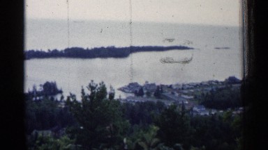 1960: the top angle view in the ocean near to green tree sand stone rock fast
