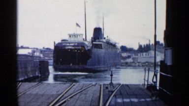 1960: giant steam boat departs from the port with steam and flag quivering