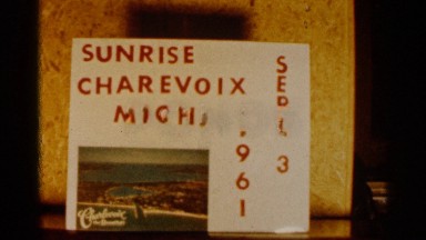 1960: view of a body of water with a sign and a large boat with the sunset