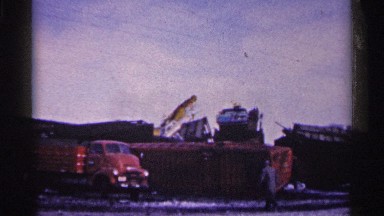 1961: two men walk toward a cargo truck parked in front of a jumble