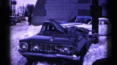 1961: vehicle lays on the side of the snowy road with significant damages