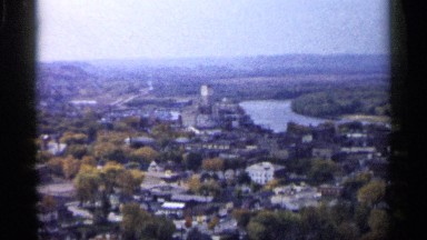 1961: aerial video view of city center, with a river flowing through it.