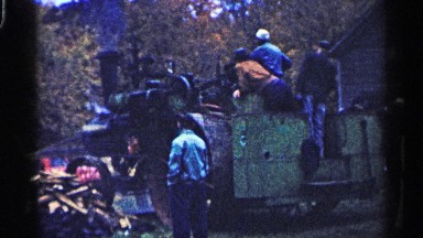 1961: An Engine Running While Several People Observe in Minnesota