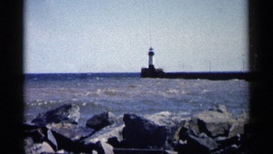 1961: tomb stone standing on the sea side captured with the rocks and waves