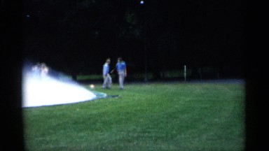 1961: two persons walking around a ground or park surrounded by trees MINNESOTA