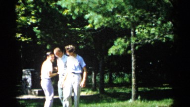 1961: three happy friends walking and laughing, enjoying their time together