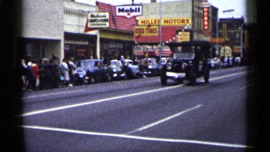 1961: a car moving slowly on the road ,while others watch it. MINNESOTA