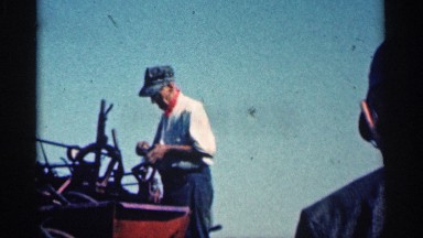 1963: elderly man working on a piece of farm equipment MONTGOMERY MINNESOTA