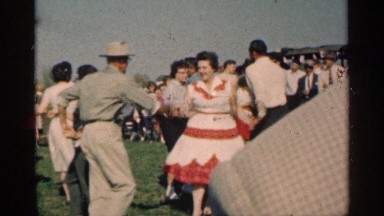 1963: the men and women dance of the park center place in green grasses near to