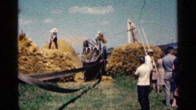 1963: A Group of People Watching Workers Making Bales of Hay in Montgomery, Minnesota