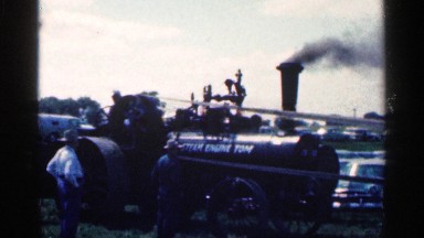 1963: steam engine tom has smoke coming out of its stack while men stand by