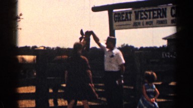 1963: view of man and his beautiful family playing with a horse behind him
