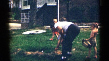 1963: three kids are watching their grandfather doing something at the garden
