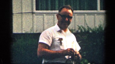 1963: man in a front yard untangling a rope. TEXAS