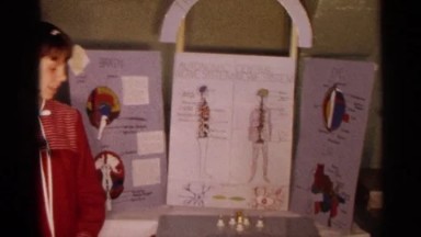 Young Girls Proudly Standing by Their Science Fair Display in Texas