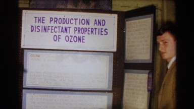 1963: a man watch the art gallery near to the boar sign write the letter