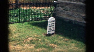 1963: green grass graveyard with a grave sign accent words are written on it