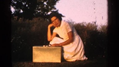 1964: Woman Posing with Suitcase Turns to Reveal Text