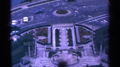 1964: cars driving through intersection near a garden within city NIAGRA FALLS