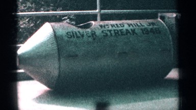 1964: metal, cylindrical item, with cone-shaped tip, lettering, seat area.