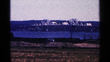 1964: scenery of distant mountain, bridge, river and countryside on a shiny day