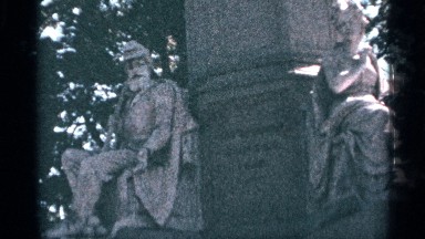 1964: Two Statues Located Near a Pillar in a Garden