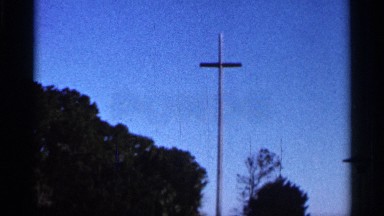 1966: trees and a cross symbol can be seen on a dark blue sky at evening hours
