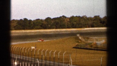 1966: red car and white car race down the track nearing the finish line