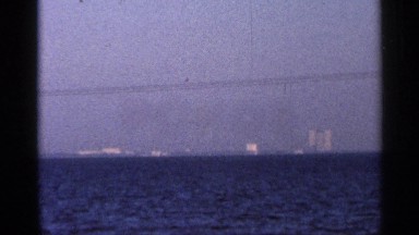 1966: a view of ocean at evening time with small tides on it and with apartments