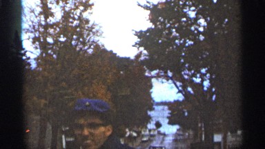 1965: a man is shown standing up talking outdoors in the middle of the street
