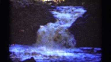 1965: old, color video of a flowing body of water that results in a spring.