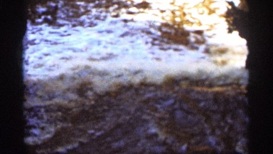 1965: current of water flows force from aside white foam present on it all over