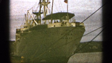 1965: a large shaped,sharp edged boat standing on harbor tied by with rope