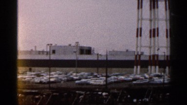 1966: large area of parking four wheeler, looking scrappy and car glides in.